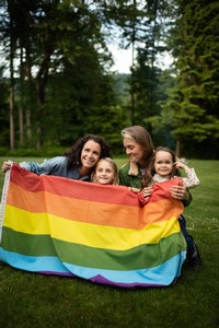 Family holding up pride flag